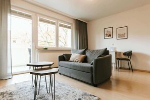 Das Wohnzimmer lädt zum Verweilen ein und mit der Fensterfront erwartet euch ein heller Raum.