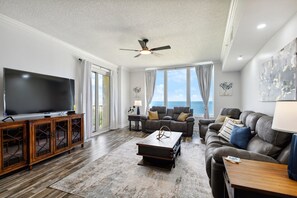 Living room with ocean view, balcony, comfy couch.