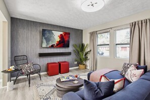 Cozy up in the inviting living room featuring a large flat-screen TV—perfect for movie nights or lazy mornings.