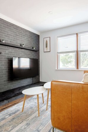 55in HDTV with streaming, wood burning fireplace and leather sofa. 