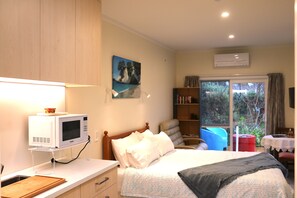 Internal view showing kitchenette, bed and lounge area with outside furniture