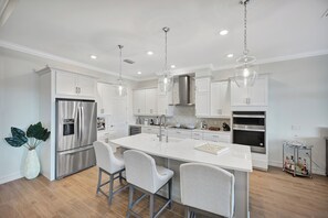 Modern gourmet kitchen with custom high end appliances & wine fridge.