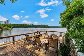 This stunning lakeside deck offers the ultimate waterfront hangout with lounge chairs for soaking up the sun and a rustic dining table perfect for meals with a view.