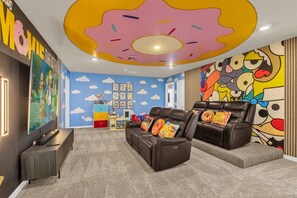 Immerse yourself in this vibrant, themed home theater with cozy recliners and playful decor—perfect for family movie nights!