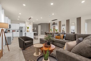 Experience comfort and style in this open-plan living area with a cozy sectional, modern kitchen, and chic decor—perfect for relaxation and entertaining.