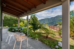 The Outstading Views Of The Surrounding Countryside And Mountais From Casa Hortensia By Ourmadeira With A Table For Two And Some Wine Glasses