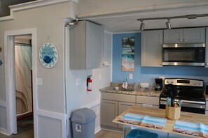 well lit kitchen area complete with island & seatng for 2