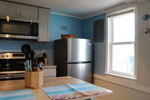 well lit kitchen area complete with island & seatng for 2