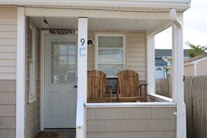 a small porch greets you as you arrive, complete with seating for two on adirondack chairs.