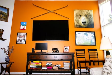 Large living room with 80" Smart TV, board games, puzzles