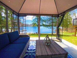 Gazebo with screened sides and cushioned seating, view of the lake