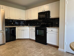 fully stocked kitchen with stove, microwave, and dishwasher
