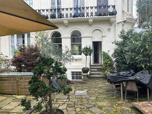 back garden with sitting area and sofa and table with chairs for outdoor dining 