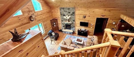 Vaulted ceiling, comfortable seating, and natural light in the living room.