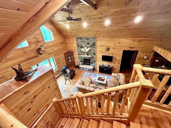 Vaulted ceiling, comfortable seating, and natural light in the living room.