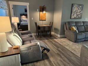 Living room with recliners, electric fireplace, games & game table.
