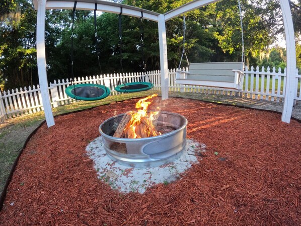 Enjoy cozy nights by the fire pit, swinging under the stars.