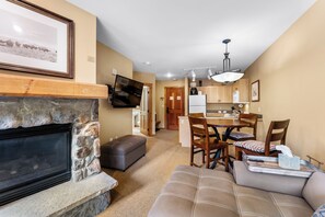 Living area with gas fireplace, mounted flatscreen TV, sleeper sofa and access to the private balcony.