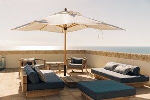 Rooftop terrace featuring a stylish Gommaire sofa, parasol and views.