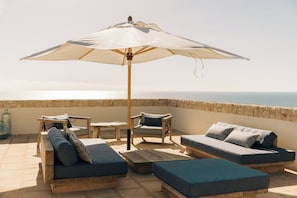 Rooftop terrace featuring a stylish Gommaire sofa, parasol and views.