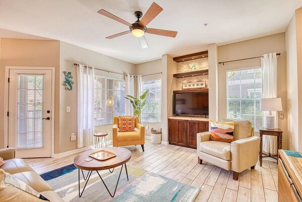 Living area with Smart TV, reading lamps and cozy blankets.