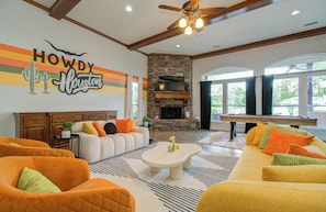 Living room with ceiling fan, fire place, and eclectic interior