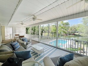 Covered porch overlooking pool and lake. 