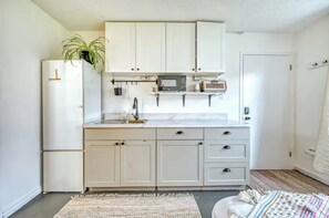 kitchenette with induction burner, microwave, toaster oven, plates etc