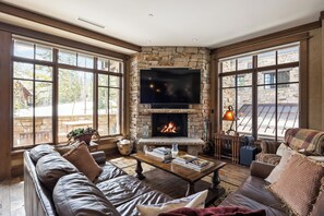 - Cozy up by the stone fireplace while watching your favorite shows on a flat screen
- Floor to ceiling windows bring in natural light & frame stunning alpine views
- Leather seating, wood floors, & rustic touches create a warm mountain retreat