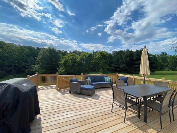 Back deck with dining area, grill, and seating area