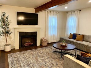 Large, cozy living room with TV and electric fire place.