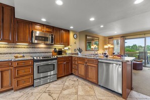 The well-equipped kitchen offers stainless steel appliances and wood cabinetry.