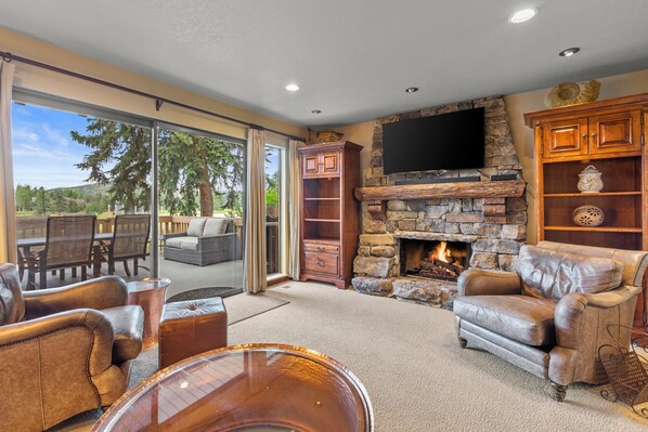 The living room is cozy and warm next to the gas burning fireplace with stone hearth.