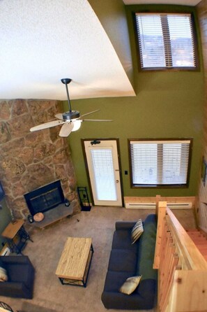 Spacious living area has a floor to ceiling fireplace and opens to the balcony