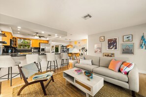 Living room with plush couch and kbar seating by the kitchen island