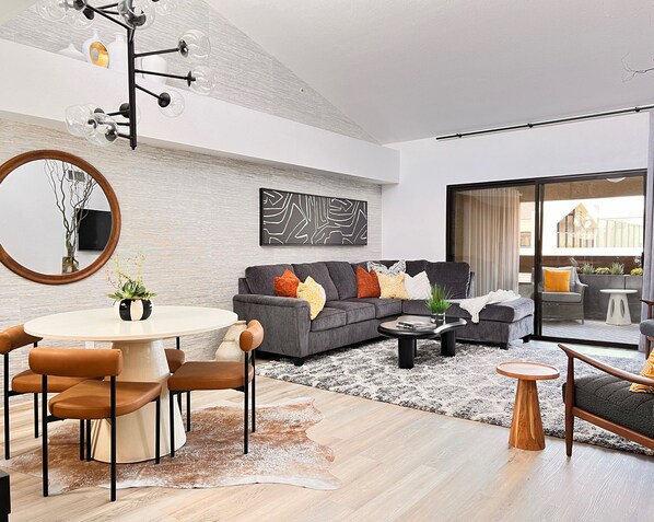 Great room has brand new furniture, large area rugs, and custom artwork.