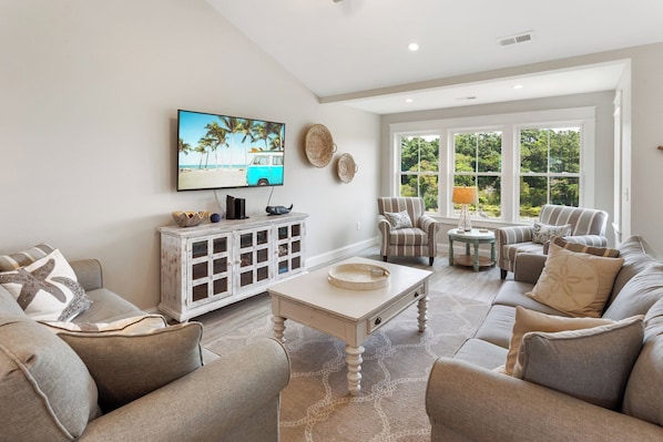 Step into an open and inviting living space where large windows bathe the room in natural light.