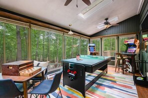 Nature meets entertainment in our game room, where expansive windows showcase breathtaking tree-lined vistas (XBOX no longer available)