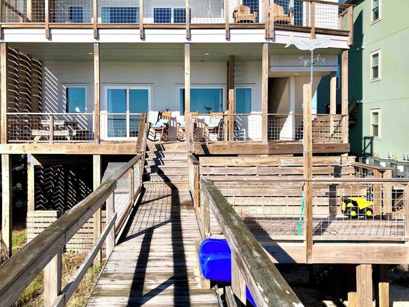 With your back to the ocean, you can see the front porch, benches for lounging and foot wash and outdoor shower for coming in off the beach. Just at the bottom right is the top of our blue slide! It goes down to sandy area with swing and clubhouse!