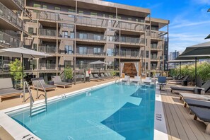 Communal Area: Sparkling blue pool with covered cabanas, sun loungers, and a wheelchair lift.