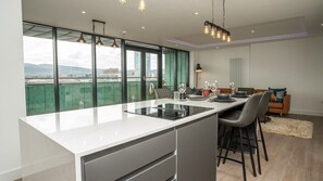 Modern open plan living space. Comfortable seating area with georgeous gas fire and a huge smart TV. Full kitchen with a huge island with dining and hob, dining area and a large balcony overlookng the titanic area with River views.