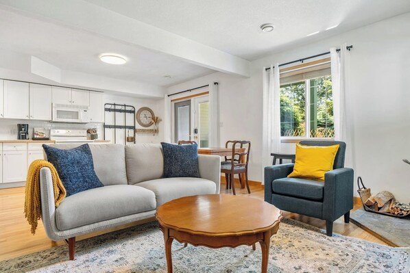 Living room with cozy seating, a Smart TV, wood-burning fireplace & board games.