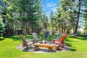 Backyard fire pit surrounded by mature trees. Please note that this is a shared space with the upstairs tenant.