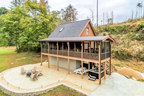 Cabin front view with firepit, hot tub and parking