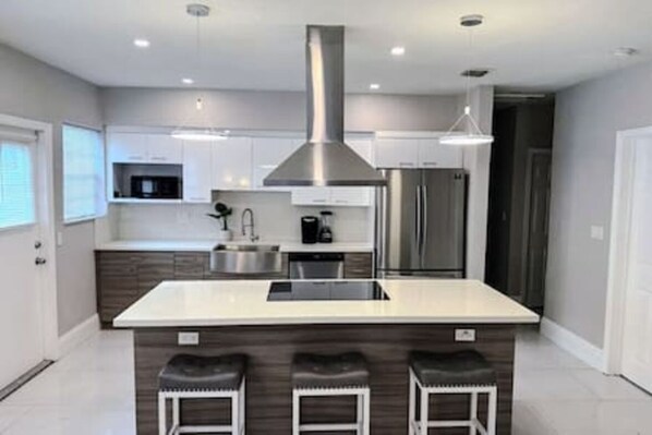 Cook and dine in style with our fully-equipped kitchen, featuring a dishwasher, dryer, electric range, microwave, and refrigerator. Basic cookware and utensils are included, plus three counter chairs for casual dining and extra seating.