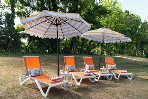Sun loungers with umbrella shade at the backyard