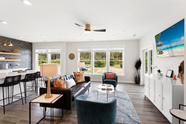 Relax in this spacious Living Area with a large Flat Screen TV and lots of brilliant, natural light.