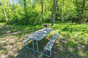 Nearby public picnic area with park-style grills and picnic tables by the creek.