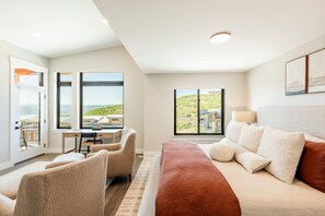 3rd level - Master bedroom 1 with king bed, accent chairs, a 65” smart TV with Apple TV, a work desk, and private balcony