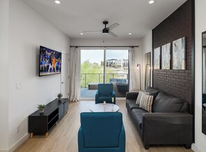 1st Floor: Warm and inviting living room featuring a Smart TV for entertainment, and designer furnishings including a sleeper sofa that converts into a Queen Bed.